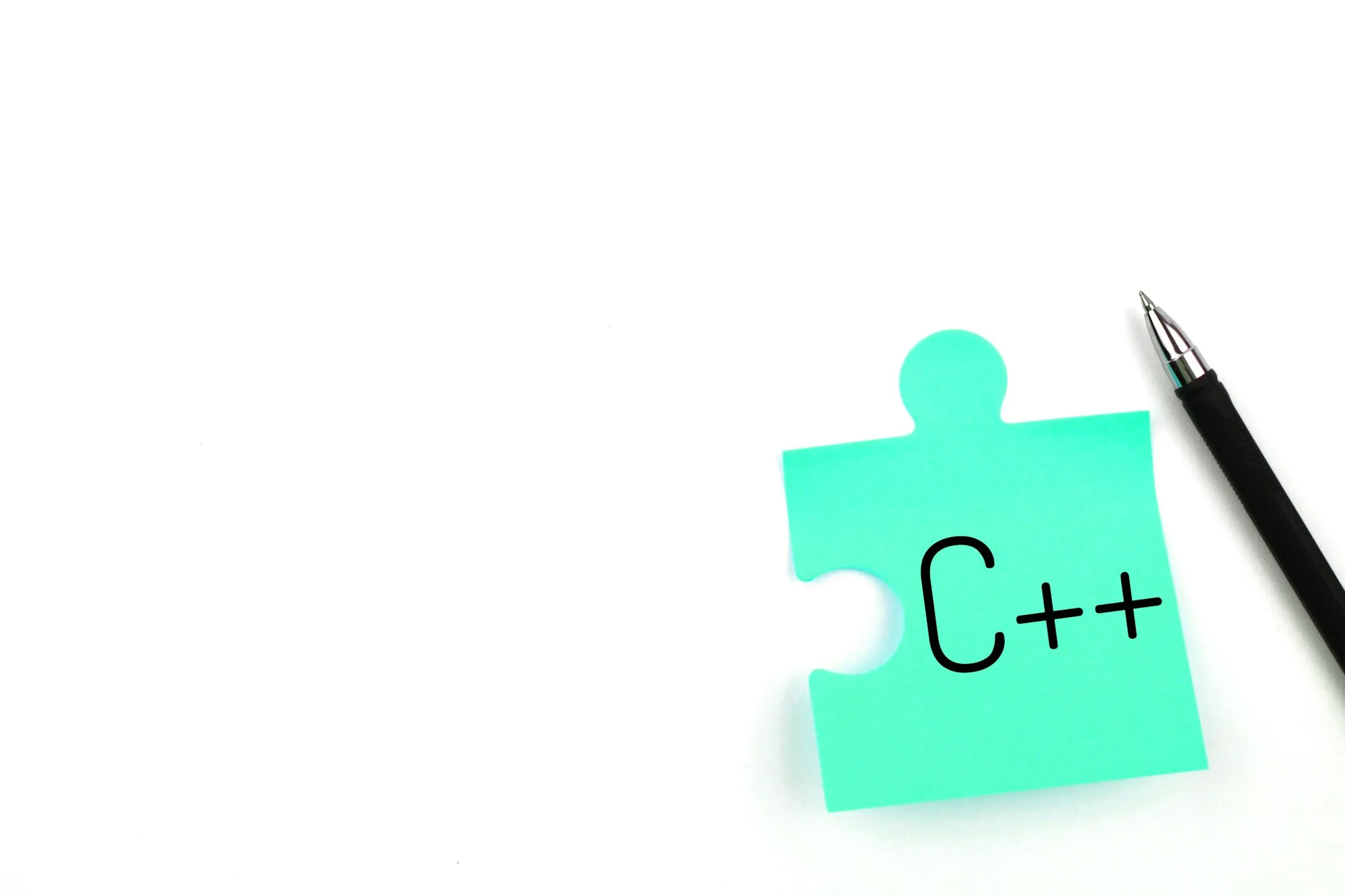 Blue puzzle sticker with inscription C++ and pen on a white background. Minimalism.